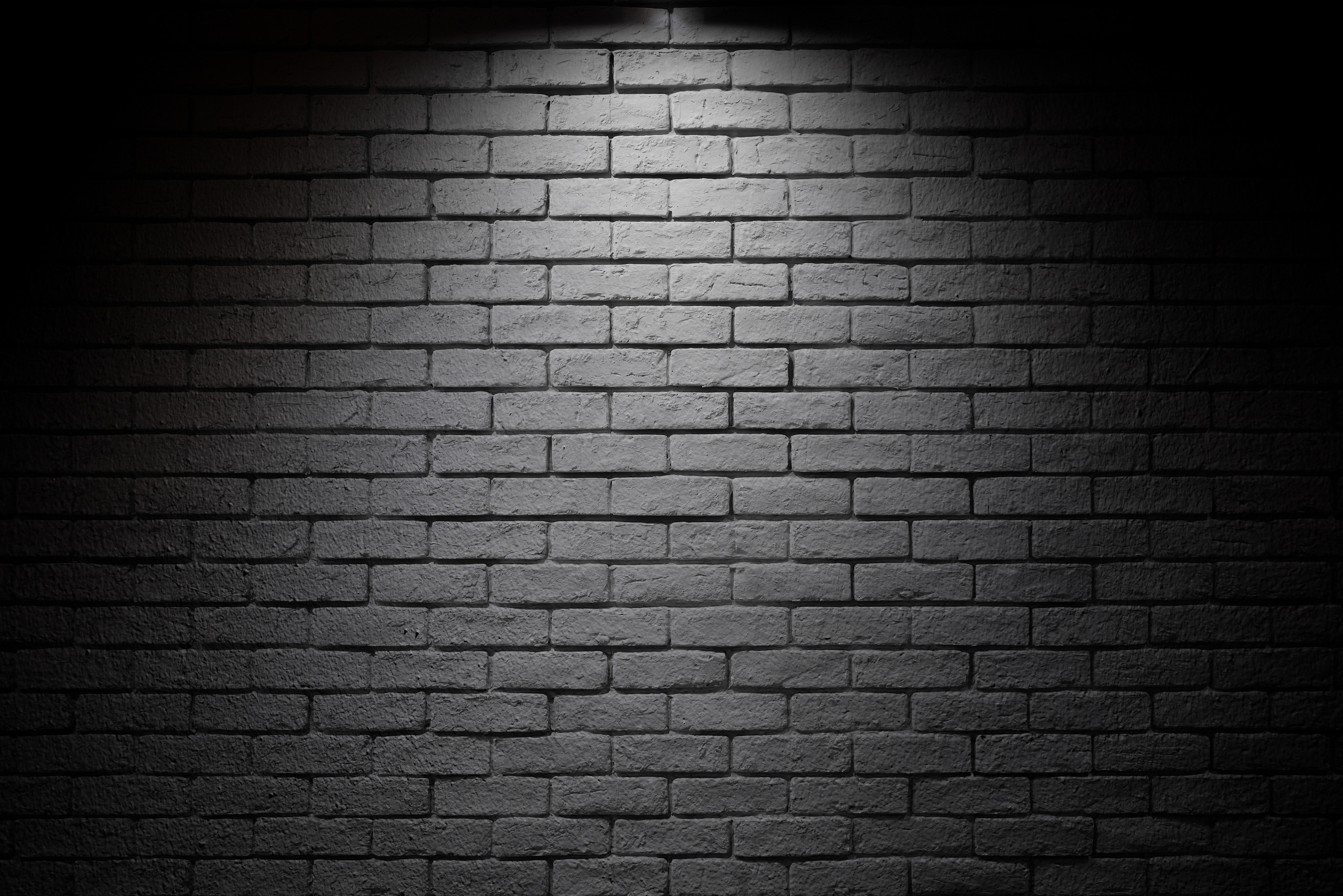 Bright spotlight illuminate dark brick wall